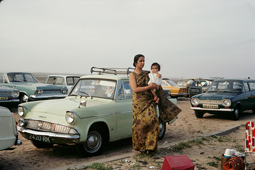 \Indian Woman Holding Child With Midcentury Cars 