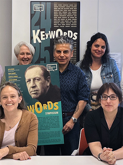 Research fellows and faculty leaders holding Keywords-themed posters