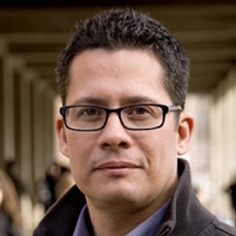 Roberto Gonzales standing in front of a school hallway