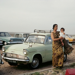 \Indian Woman Holding Child With Midcentury Cars 