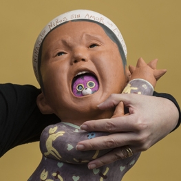 Artist Kukuli Velarde holding a ceramic sculpture of an infant