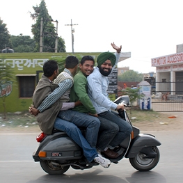 Four men riding a bike