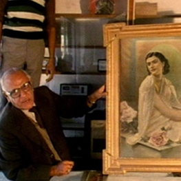Man holding a paining with a woman on it