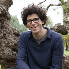 portrait of scholar Benjamin Wurgaft sitting on a tree