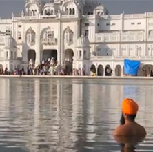 South Asian Man in Water Staring at Golden Temple in Amritsar