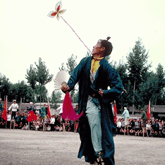 Stilt Dancer Looking at Flower